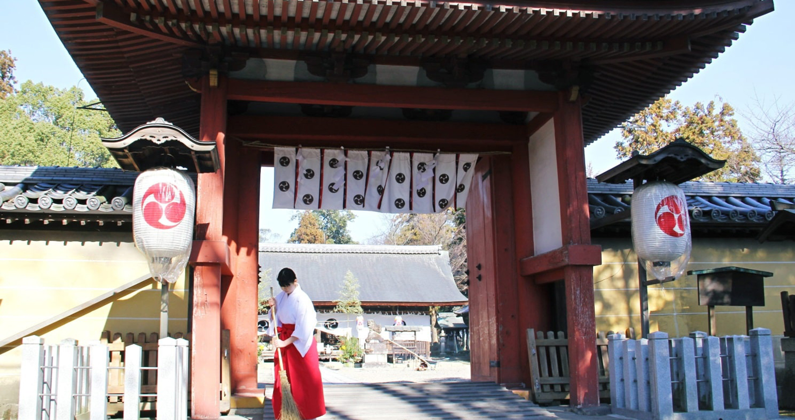 豊満神社の門前の写真と巫女が掃除している写真