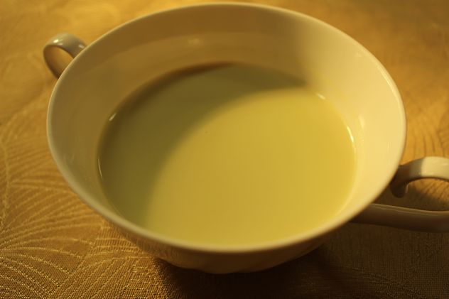 スープカップに注がれた黄緑色のグリンピースのポタージュの写真