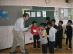 外人の男性を身振り手ぶりで英語で会話をしている生徒達の写真