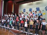 ステージの上で整列した生徒達が合唱をしている写真