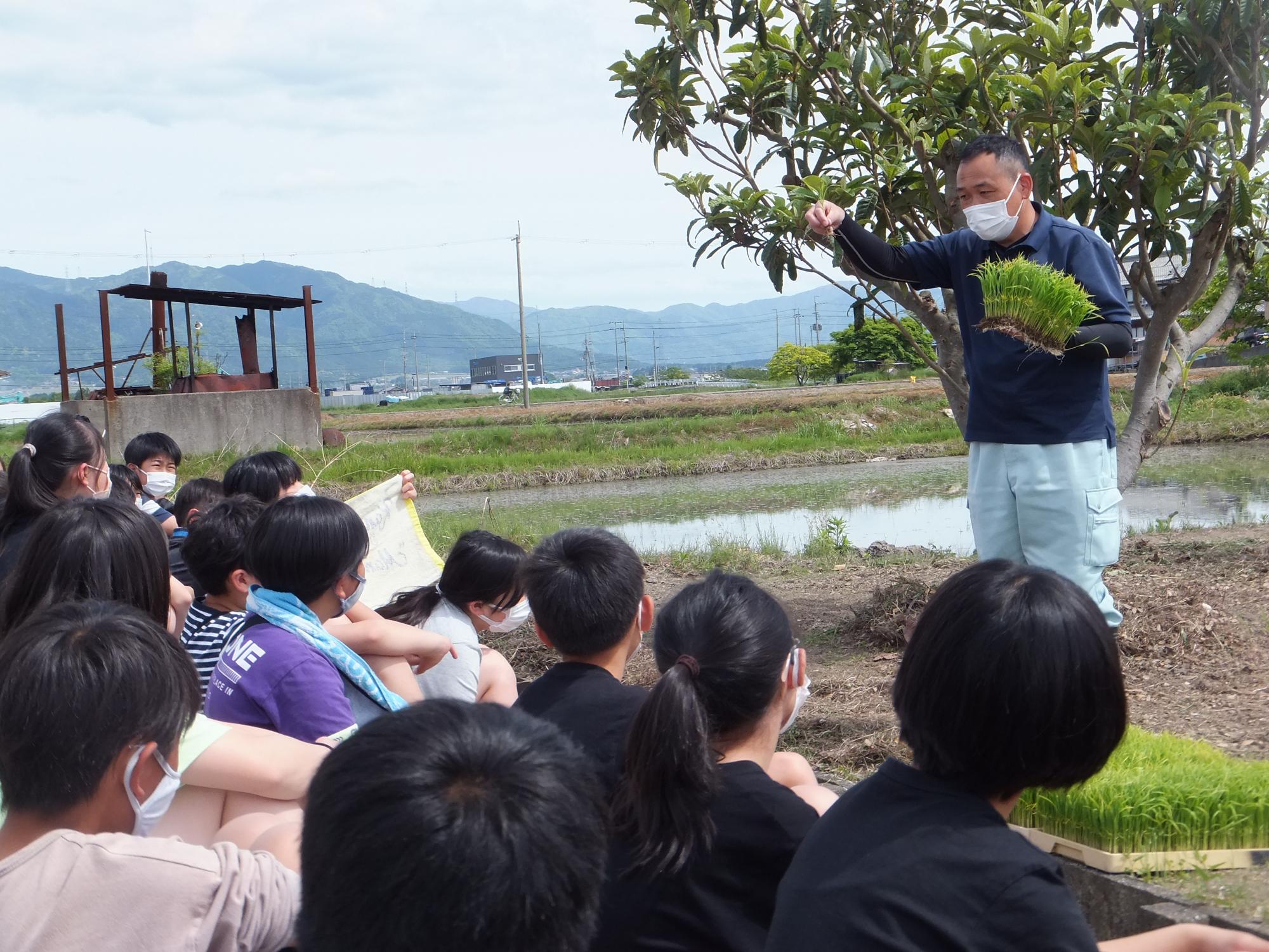 田植えのやり方を聞く児童たち