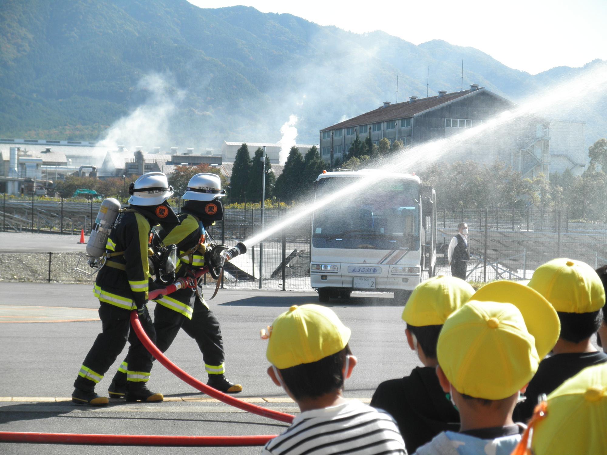 消防士の放水訓練を見学するこどもたち