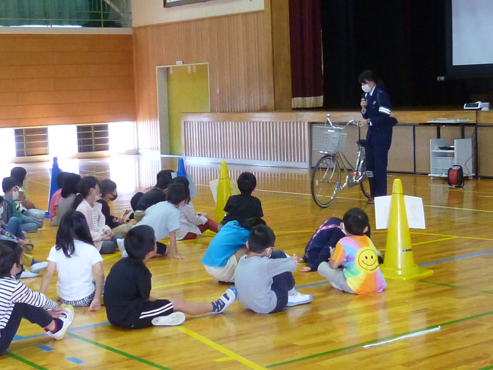 女性警察官が自転車の点検の仕方を説明している。