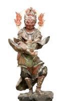 炎の光背をつけ、両手を下げて前で交差させて、左の膝を曲げている仏像の写真