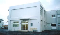 箱型でL字型に建てられた真っ白な外壁が目立つ、二階建ての愛知川東小学校区学童保育所の写真