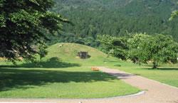 山のに囲まれた緑豊かな依智秦氏の里古墳公園の写真